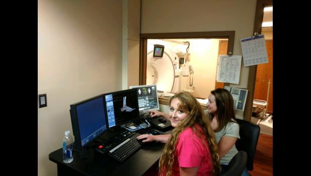 Radiology technicians Rebecca Bryan and Marla Guptill point out some of the technological advancements present in the new CT scanner. Del Bartels