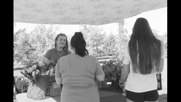 Visitors browse the table of Unruly Petals.