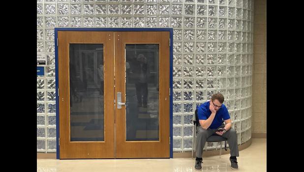 Garretson school district Business Manager Jacob Schweitzer sits outside the school library during an executive session of the school board Feb. 23. Photo: Stu Whitney, South Dakota News Watch