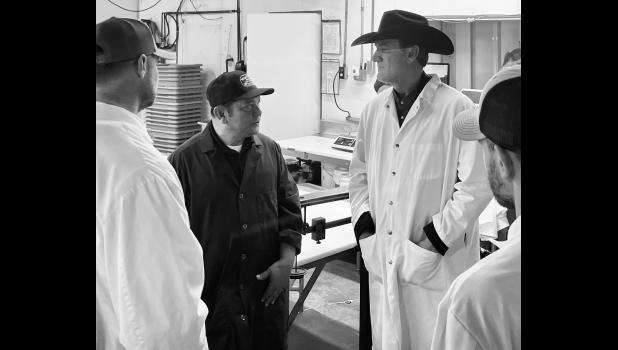 Ken Charfauros, owner of Wall Meat Processing Plant, discusses the Cooperative Interstate Certification (CIS) program with Lt. Gov. Larry Rhoden at the Wall facility. Photo courtesy of Elizabeth Meighen