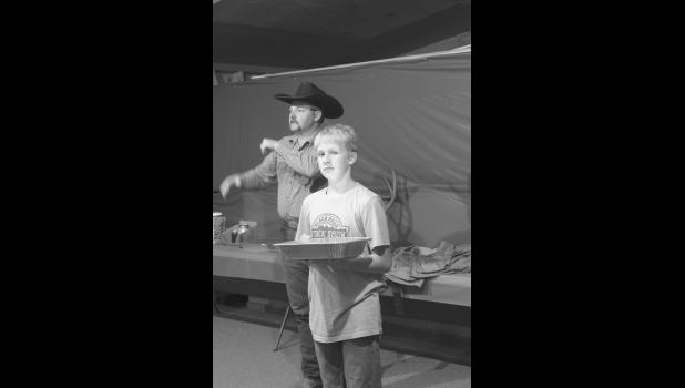 Jaxon Erikson helps show off the auction items.